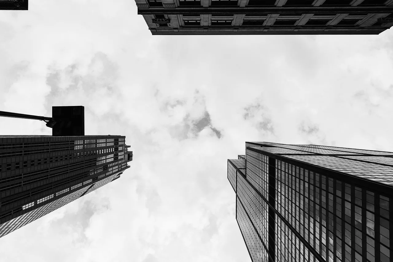 view of skyscrapers with fluffy clouds overhead