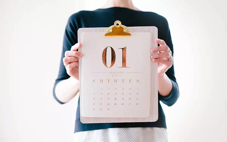 woman holding a calendar clipped to a clipboard