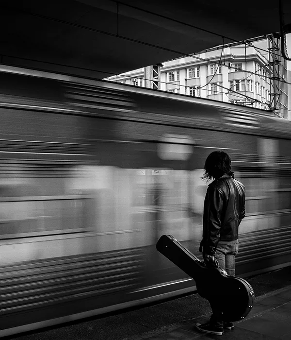 blurred speeding train and a guy with a guitar