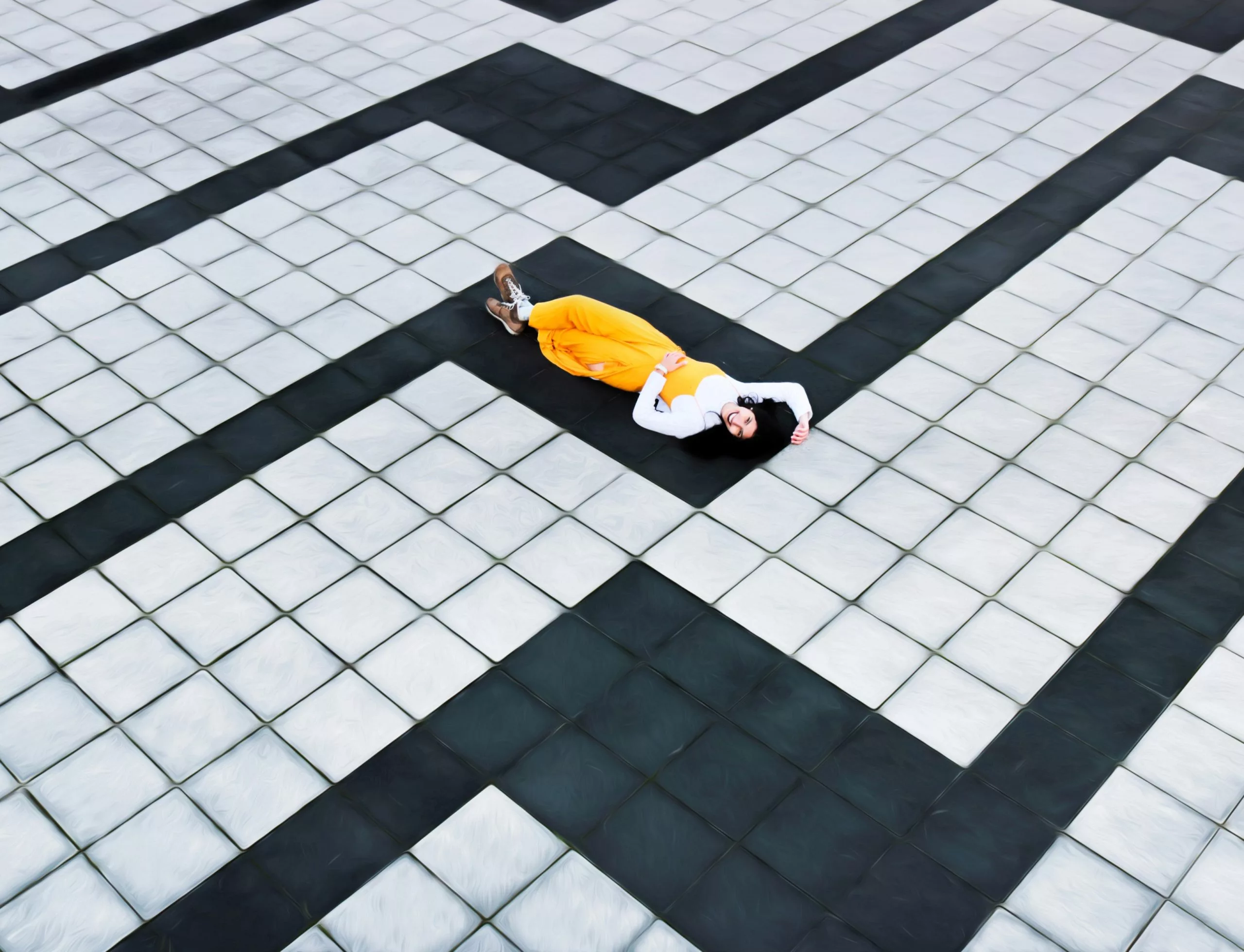 woman in yellow pants lying on tiled floor