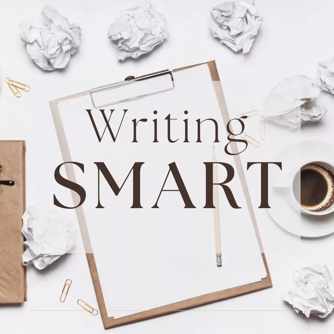 Blank clipboard and a coffee cup among crumpled papers with words: Writing Smart.